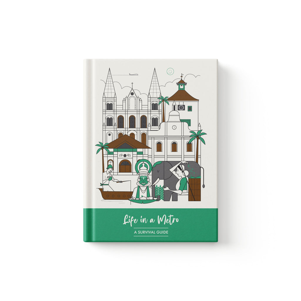 A hardcover notebook titled 'Life in a Metro' by Monkart, featuring a minimalist line art illustration of a Kochi street scene with a cathedral, elephant, and mosque on an off-white cover with a solid green band at the bottom.