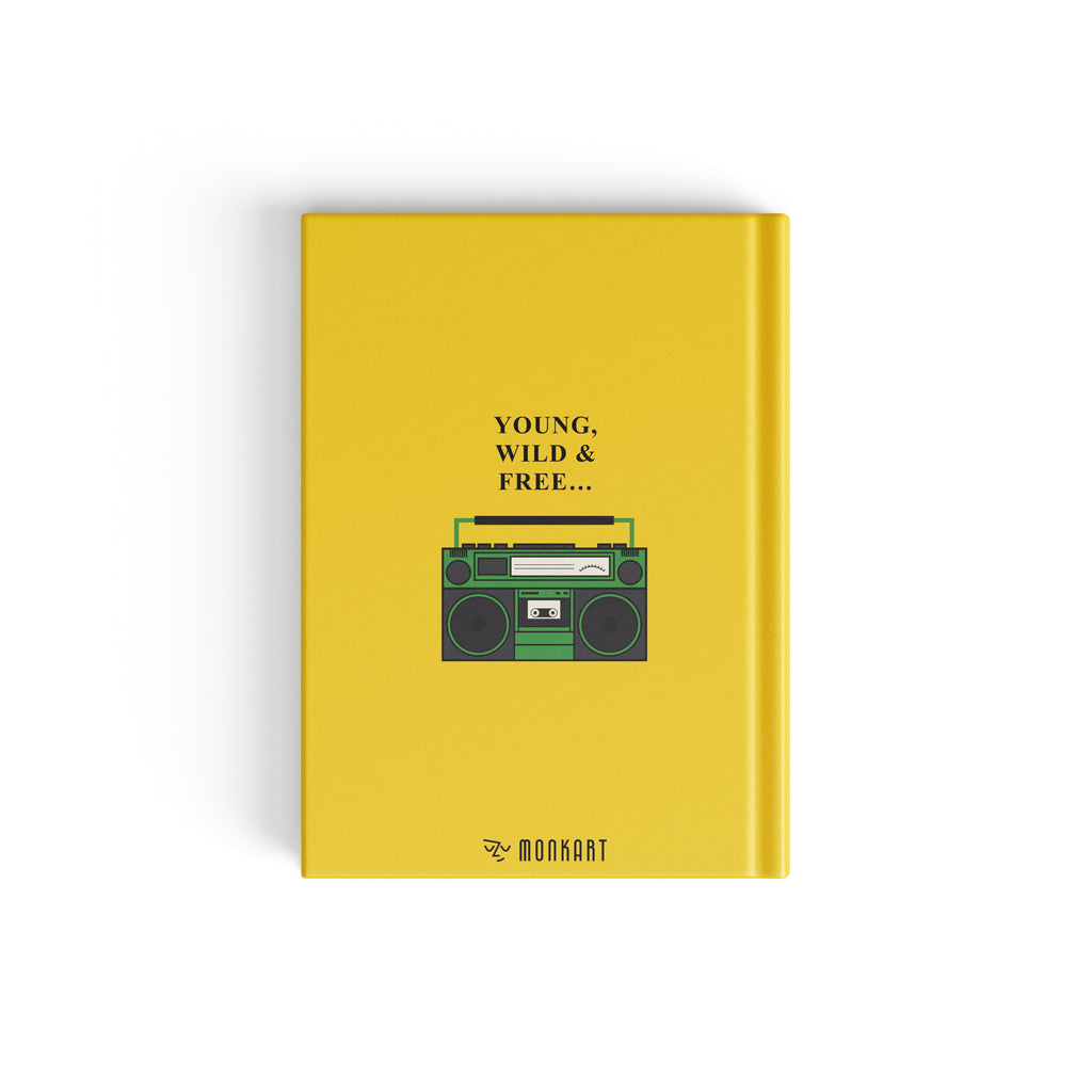 A yellow hardcover notebook with a retro cassette tape graphic on the front cover, featuring the text 'YOUNG. WILD & FREE'.